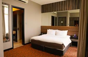 um quarto com uma cama grande num quarto em Aqueen Hotel Paya Lebar em Singapura