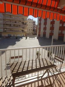 a wooden bench sitting on a balcony with an umbrella at TulStig DelMar in Vilanova i la Geltrú