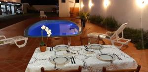 a table and chairs with a table and a pool at Pousada Cris Garden Bed&Breakfast in Foz do Iguaçu