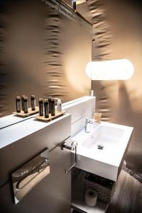 Un baño con un lavabo blanco y un espejo. en Miluna, en Hormigos