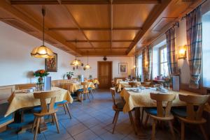 ein Restaurant mit Tischen und Stühlen in einem Zimmer in der Unterkunft Hotel garni Sterff in Seeshaupt