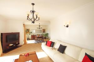 un soggiorno con divano bianco e TV di Villa Saint Thomas by Algarve Vacation a Carvoeiro