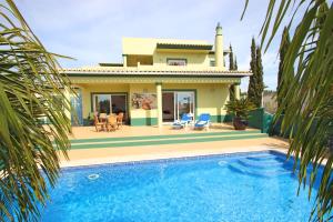 a villa with a swimming pool in front of a house at Villa Saint Thomas by Algarve Vacation in Carvoeiro