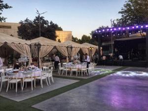 un grupo de mesas y sillas bajo tiendas con luces en City Palace Hotel Tashkent, en Tashkent