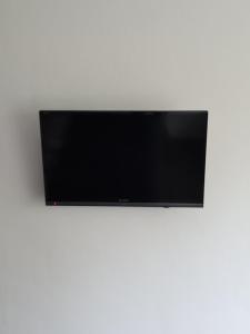 een flatscreen-tv op een witte muur bij De Stoof, complete studio voor 2 personen in Renesse