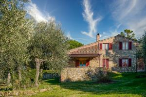 una casa in pietra con finestre rosse e un albero di Villa Capanna a Siena