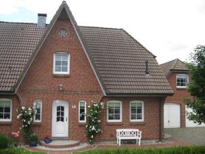 a red brick house with a bench in front of it at Beeck - FeWo mit Terrasse und Strandkorb in Oeversee