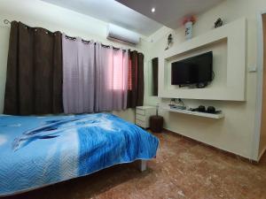 a bedroom with a bed and a tv on the wall at Ezore Yam Apartmens - Elmali'akh St. 4 in Bat Yam