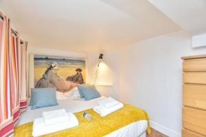 1 dormitorio con 1 cama con una pintura en la pared en CMG Ile Saint Louis en París