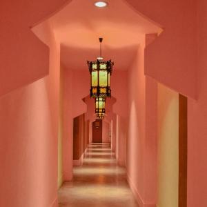 a hallway with pink walls and a chandelier at Shanghai Mansion Bangkok - SHA Extra Plus in Bangkok