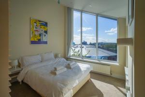 a bedroom with a bed and a large window at Royal Stuart Lane - Townhouse by the Bay with Parking in Cardiff