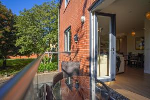 a balcony with a glass table and chairs on a house at Royal Stuart Lane - Townhouse by the Bay with Parking in Cardiff