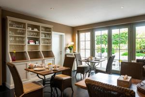 a restaurant with tables and chairs and windows at B&B La Cereza in Oudenaarde