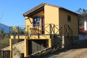 Casa pequeña de color amarillo con balcón en Palheiro do Malgas, en Lousã