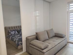 ein Wohnzimmer mit einem Sofa und einem Bett in der Unterkunft Apartment Ainiai in Panevėžys