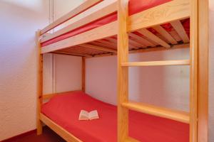 a bunk bed with a book on the bottom bunk at Vacancéole - Résidence Vallée Blanche in Les Deux Alpes