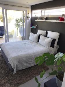 a bedroom with a bed with white sheets and pillows at EEZY BREEZY HOLIDAY HOME in Knysna