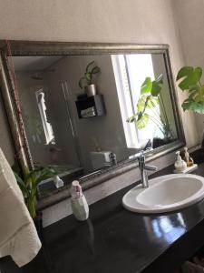 a bathroom with a sink and a large mirror at EEZY BREEZY HOLIDAY HOME in Knysna