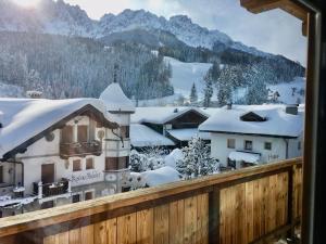 einen Balkon mit Blick auf ein schneebedecktes Dorf in der Unterkunft Appartements Innerkofler Mountain Home in Innichen
