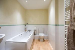 a bathroom with a tub and a toilet and a sink at Basingstoke Central Apartments in Basingstoke