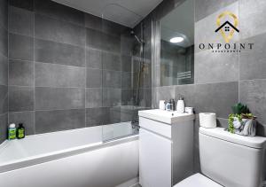 a bathroom with a toilet and a tub and a sink at OnPoint - Spacious 2 Bed Apt - FREE Parking in Reading