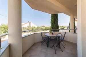 patio con mesa y sillas en el balcón en Apartments Lovas, en Vodice