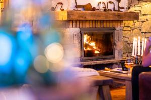 a fireplace with a person sitting in front of it at Parc Madeleine - CHALETS in Saint-François-Longchamp