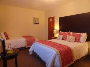 a hotel room with two beds with red pillows at Orley House B&B in Drogheda