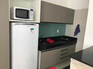 uma pequena cozinha com frigorífico e micro-ondas em Studio Everest Flats no Recife