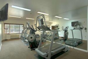 a gym with several tread machines in a room at Azure Hotel&Suites Ontario Trademark Collection by Wyndham in Ontario