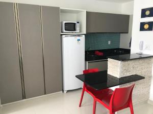 a kitchen with a refrigerator and a table and chairs at Studio Everest Flats in Recife