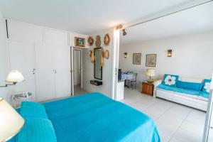 1 dormitorio con 1 cama azul y 1 sofá en Apto cómodo y funcional, en la mejor ubicación! Puerto y playas a pie., en Punta del Este