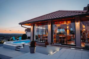 a house with a view of a pool and a patio at Holiday House Belajec in Popovača