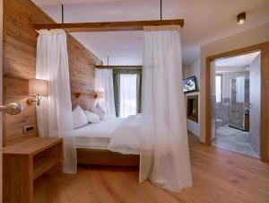 a bedroom with a large bed with a canopy at Chalet Degli Angeli in Folgarida