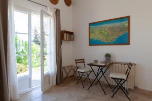 La Motte-dʼAiguesにあるChambre d'hôtes le Mirailのテーブルと椅子、窓が備わる客室です。