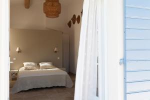 a bedroom with a bed and a white curtain at Chambre d'hôtes le Mirail in La Motte-dʼAigues