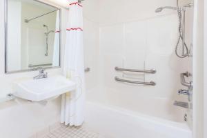 een witte badkamer met een wastafel en een douche bij MainStay Suites Chicago Hoffman Estates in Hoffman Estates