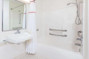 a white bathroom with a sink and a shower at MainStay Suites Detroit Auburn Hills in Auburn Hills