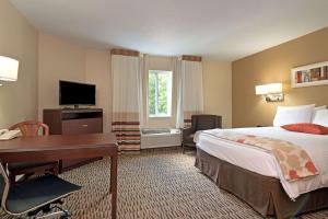 a hotel room with a bed and a desk and a computer at MainStay Suites Detroit Auburn Hills in Auburn Hills