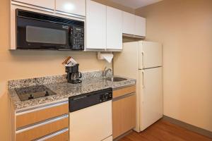 a kitchen with a sink and a microwave and a refrigerator at MainStay Suites Greensboro in Greensboro