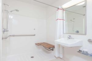 a white bathroom with a sink and a shower at MainStay Suites Detroit Farmington Hills in Farmington Hills