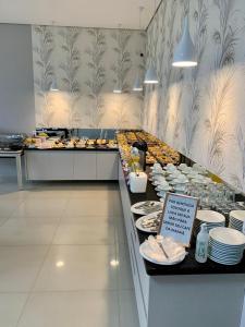 a buffet line in a restaurant with plates of food at Hotel e Locadora Vizon in Vilhena