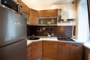 a kitchen with wooden cabinets and a stainless steel refrigerator at Kyiv Center Romantic Apartment in Kyiv