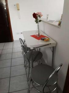 una mesa con dos sillas y un jarrón con flores. en Amanhecer do sol, en São Paulo