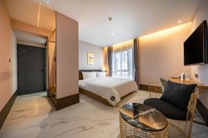 a hotel room with a bed and a chair at Brown Dot Hotel Signature in Busan +43 photos