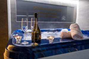 a bottle of wine and glasses in a bath tub at Luxury Villa Rebecca in Brestovac