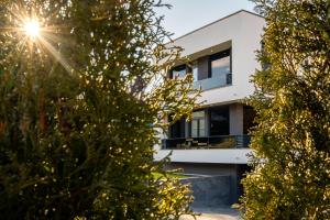 dom widziany przez drzewa w obiekcie Luxury Villa Rebecca w mieście Brestovac