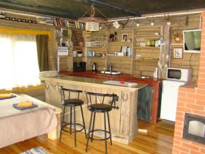 una cocina con isla en una cabaña de madera en A, kas tja byus?, en Aglona