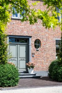 a brick building with a door and a flower pot at B&B La Cereza in Oudenaarde