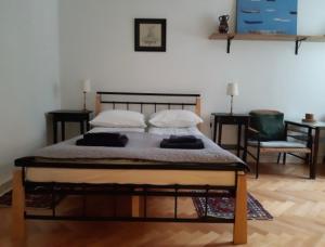 łóżko z 2 poduszkami i krzesłem w pokoju w obiekcie Dziesiątka w Olsztynie